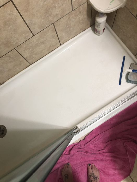 The same reviewer's after photo showcasing a significantly cleaner shower floor