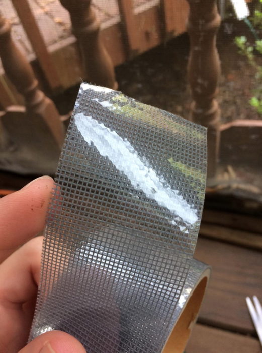 A reviewer displays the opened roll of tape, which closely resembles the texture of a screen
