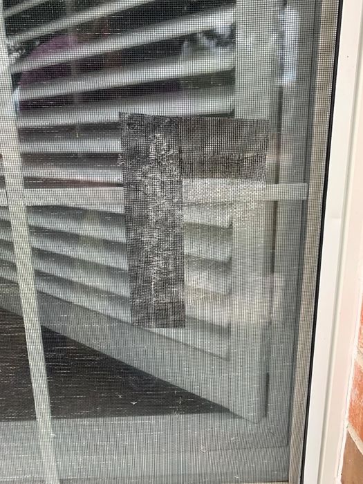 Two rectangular gaps in a screen neatly covered with the repair tape