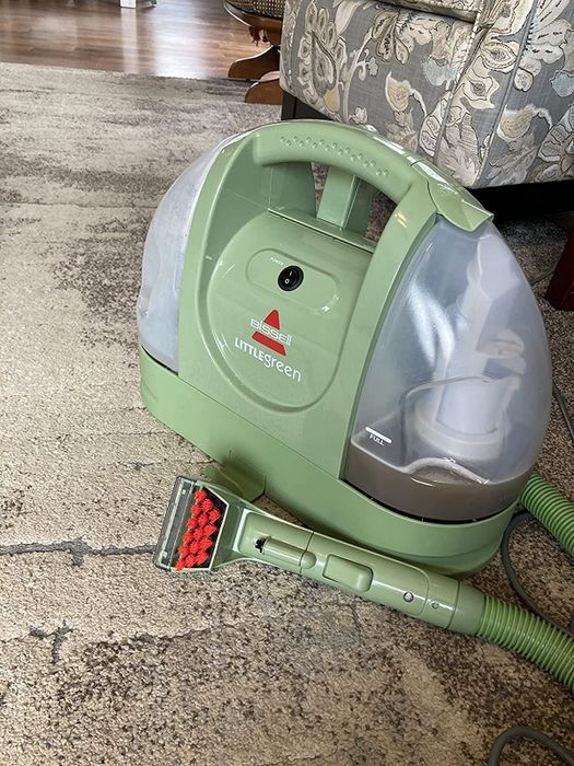 A reviewer demonstrates the machine in action on a carpeted surface
