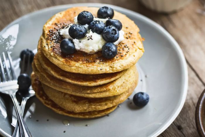 Nutritious Banana Oat Pancakes with Blueberries, Coconut Cream, and Chia Seed Topping