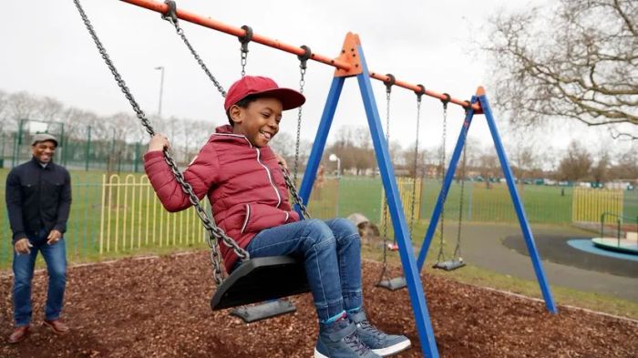 A father and son enjoying time together on the swings at a park