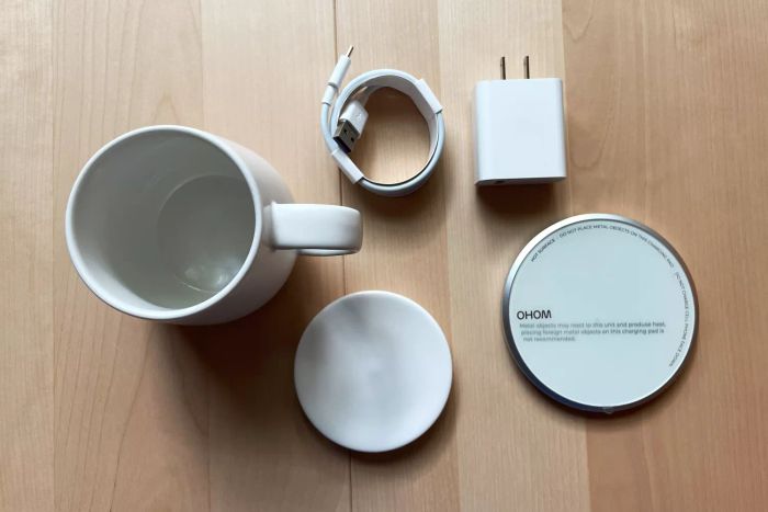 Components of the Ohom Ui Self-Heating Mug Set arranged on a wooden table