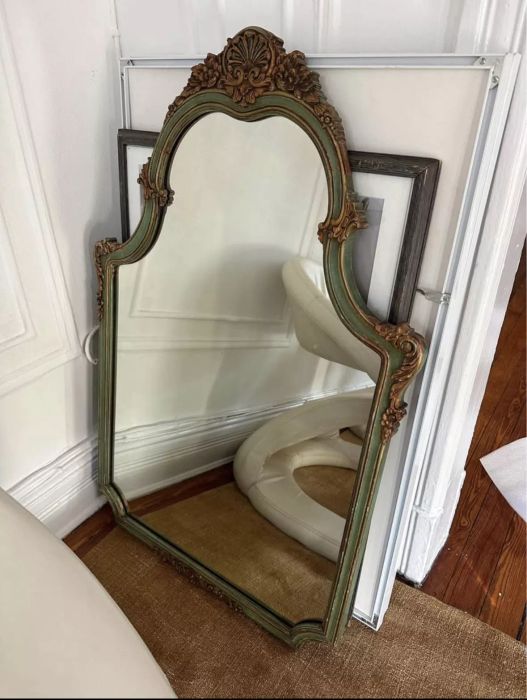 ornate mirror leaning against wall