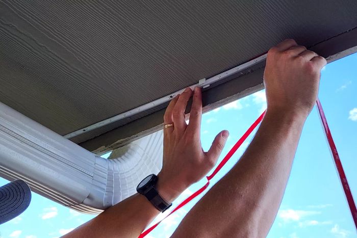An individual installs the Govee WiFi Outdoor LED Strip Lights.