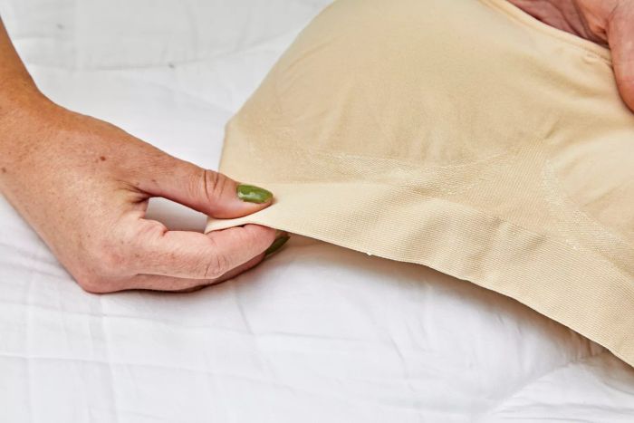 A person is feeling the fabric of the Underoutfit The Comfort Shaping Bra.