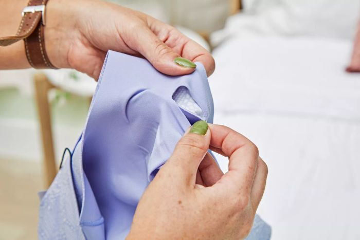 A person is removing the inserts from the Evelyn Bobbie Defy Bra.