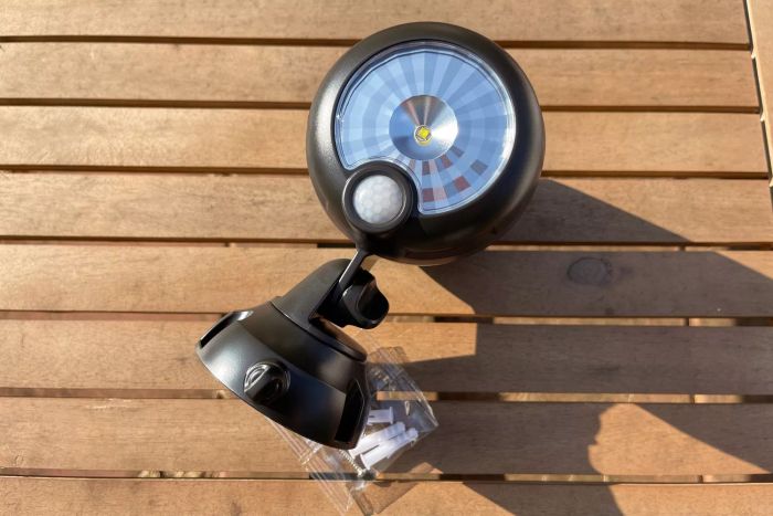 Beams MB360XT 200 Lumen Battery Powered Motion Sensing LED Spotlight positioned on a wooden deck