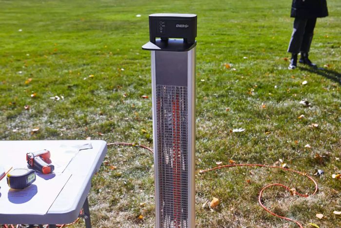 EnerG+ Electric Patio Heater in lawn beside table with thermometer and measuring tape outside