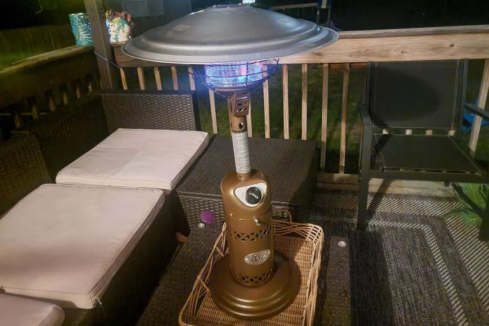 Bali Outdoors Portable Patio Heater placed on a patio beside outdoor furniture.