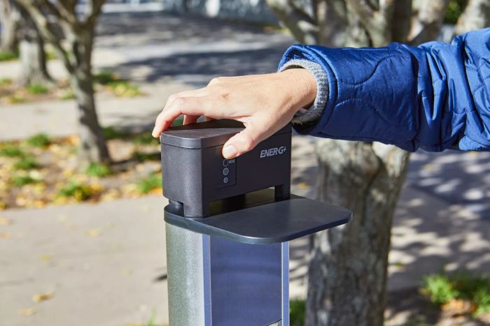 Person pressing the button to operate the EnerG+ Electric Patio Heater outdoors.