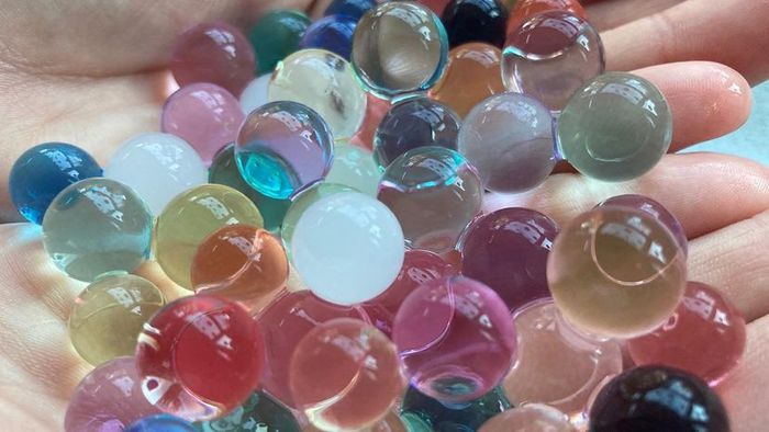 Orbeez are tiny, colorful, squishy beads about the size of ball bearings, made from polymers such as acrylic acid, sodium hydroxide, and water.