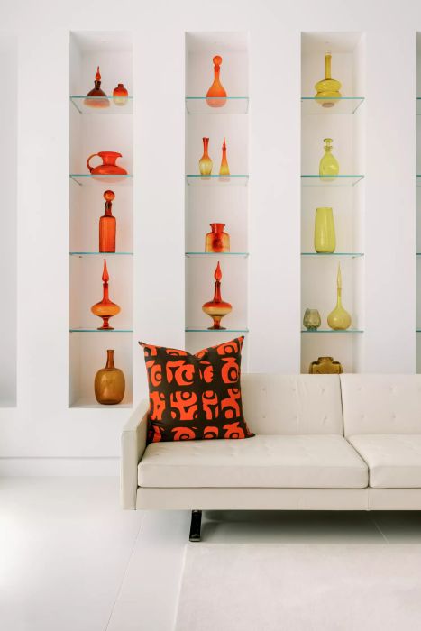 bookshelves adorned with vibrant glass pieces in various colors