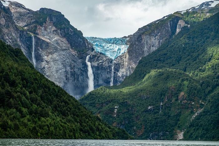 A glacier melting into cascading coastal waterfalls