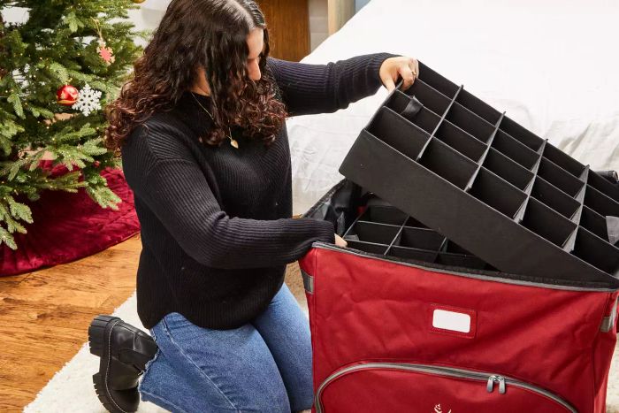 A person is seen taking organizers out of the Balsam Hill Deluxe Rolling Ornament Chest
