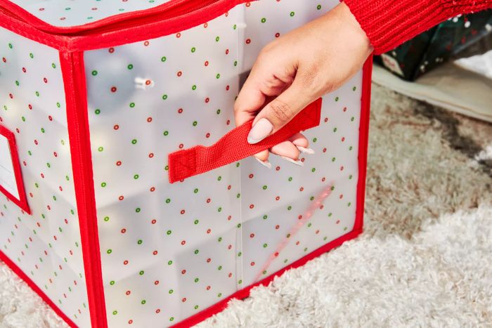 A person pulls the handle on the Sattiyrch Plastic Christmas Ornament Storage Box.