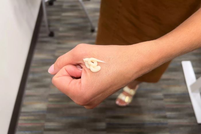 A person holding the Replenix Retinol Smooth + Tighten Body Lotion in their hand