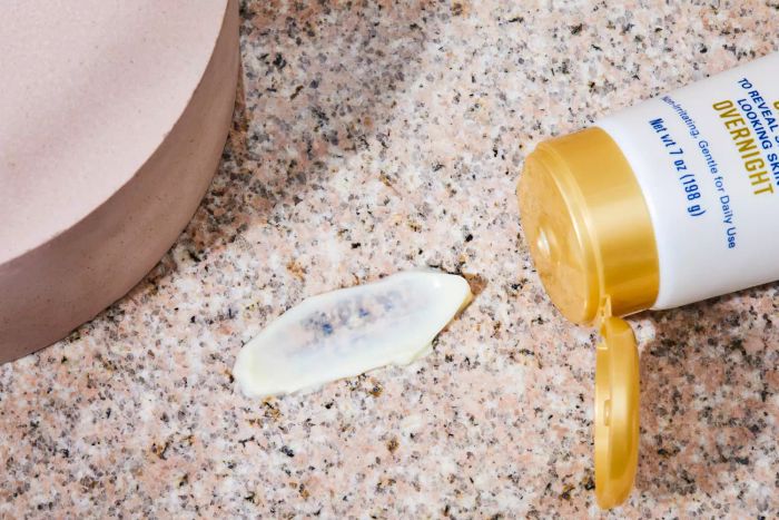 A close-up of a swatch of Gold Bond Age Renew Retinol Overnight Body and Face Lotion on a marble surface