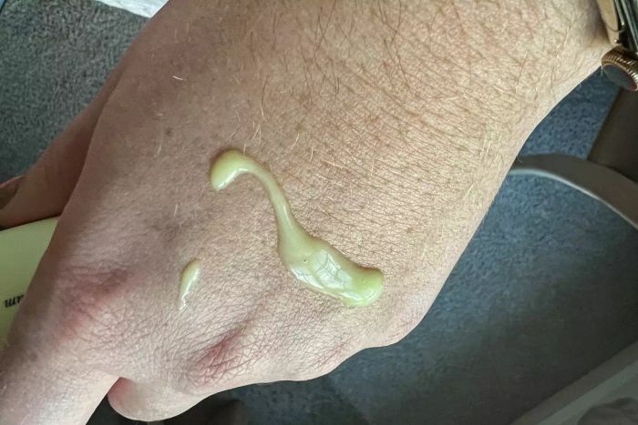 An individual applying Soft Services Software Update Retinol Body Serum to their hand