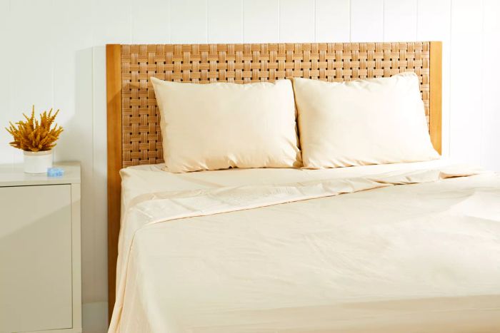 The Brooklyn Bedding Deep Pocket Tencel Sheets displayed on a bed with a woven headboard