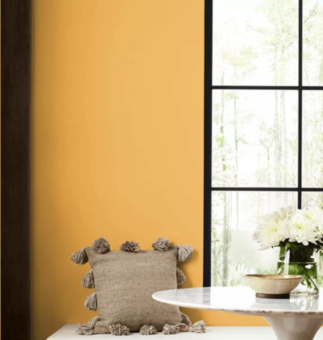 A wall painted in a vibrant golden yellow shade.