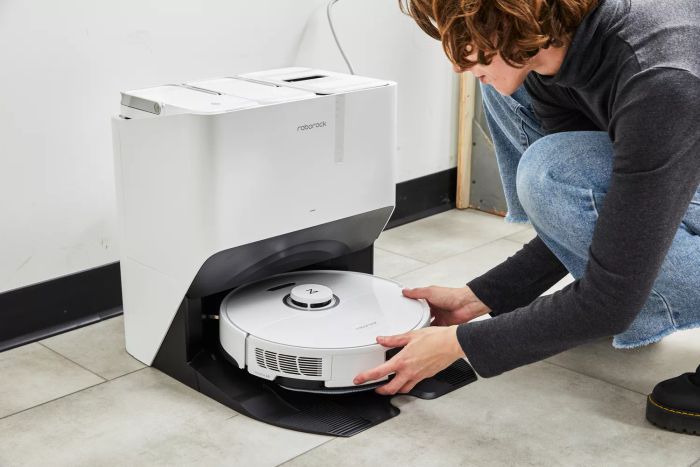 A person placing the Roborock S8 Pro Ultra Robot Vacuum into its charging station