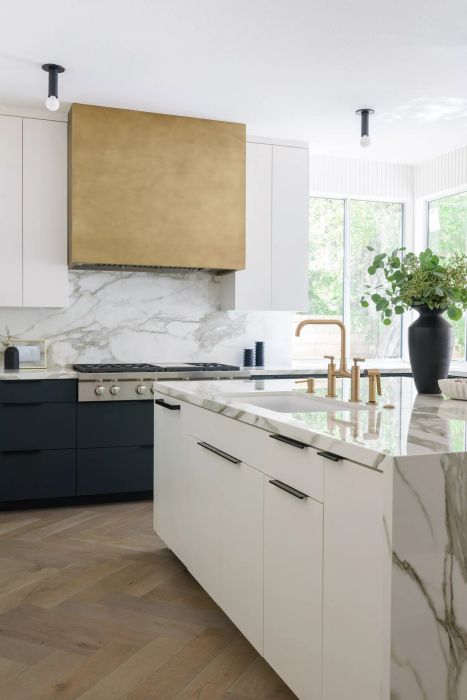 A kitchen featuring a sleek marble backsplash and countertops.