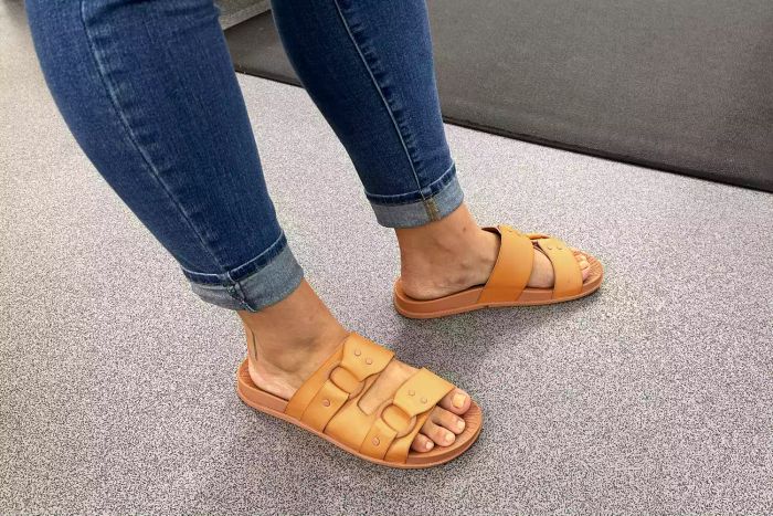 A person wearing the Reef Cushion Vera Cruz Slide outdoors.