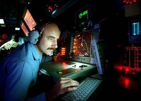 A technician wearing a headset operates advanced radar systems in a high-tech environment.