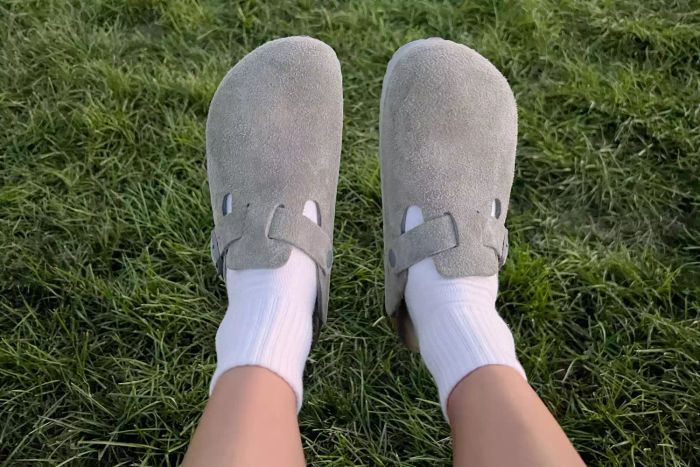 A close-up of someone wearing the Birkenstock Women's Boston Soft Footbed Clog over white socks.