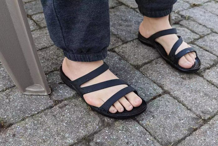The Crocs Women's Swiftwater Sandal being worn on stone outdoors.