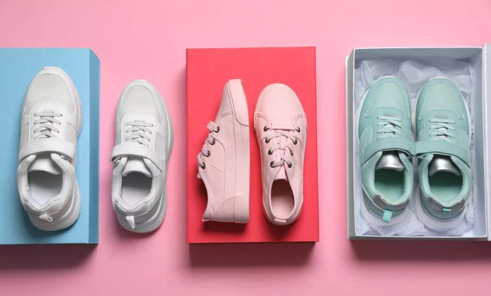 A flat lay arrangement showcasing various trendy sports shoes on a pink backdrop