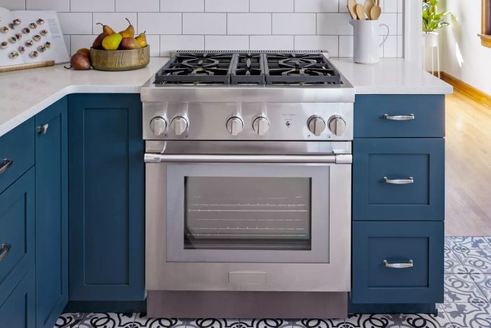 A warm and inviting kitchen featuring a gas range and a four-burner stove with pears placed on the countertops