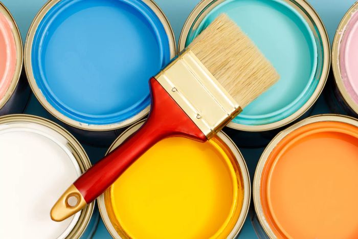 Paint cans, brushes, and tips on choosing the ideal interior paint color that’s also good for your health