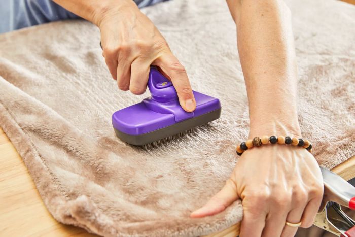 A person brushing out the Bare Home Microplush Fleece Blanket