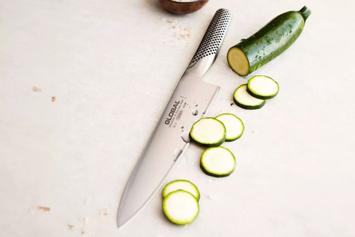 Global Classic 8-Inch Chef's Knife slicing through zucchini