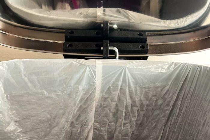 A detailed view of the hinge mechanism on the back of the FDW 13 Gallon Kitchen Step Trash Can