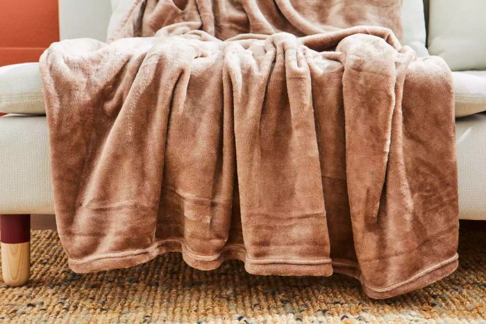 The Bare Home Microplush Fleece Blanket draped across a couch