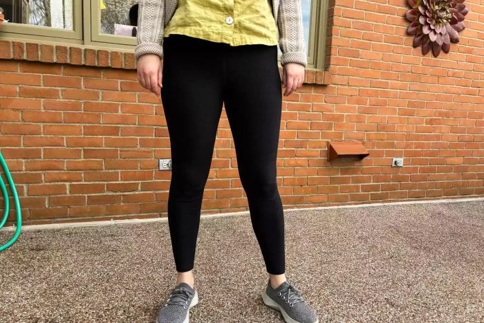 An individual stands outdoors dressed in Vuori Elevation Ruched Leggings