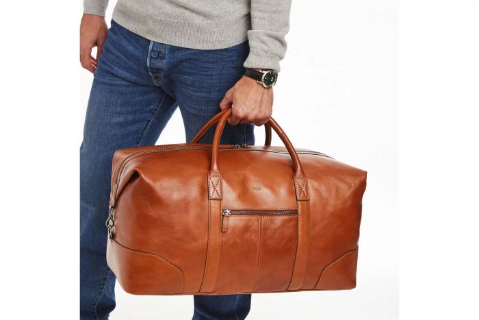 A person holding the Mark & Graham Leather Overnighter bag.