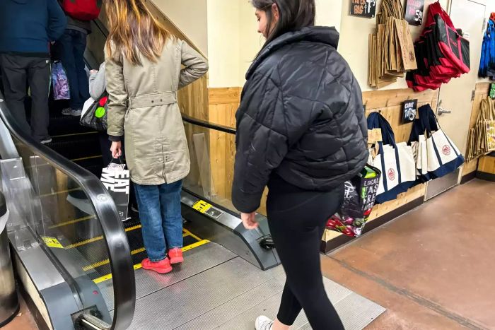 Someone walks through a store wearing the Spanx Booty Boost Active 7/8 Leggings