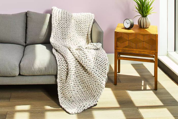 Bearaby Cotton Weighted Blanket draped on a sofa