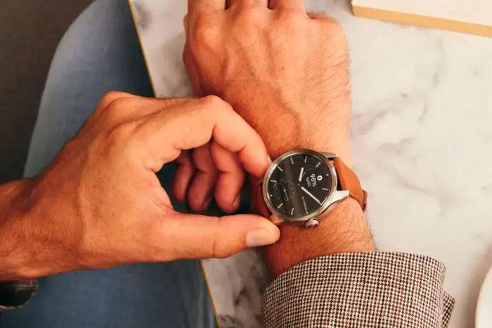 A person adjusting the dial of the Withings ScanWatch 2 while wearing it on their wrist