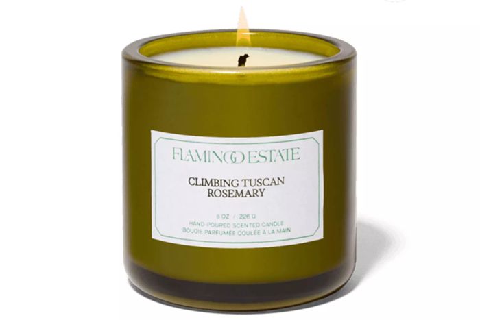 A Flamingo Estate Climbing Tuscan Rosemary Candle burning brightly.