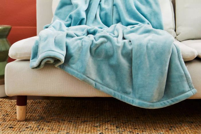 The L.L. Bean Wicked Cozy Blanket resting on a sofa