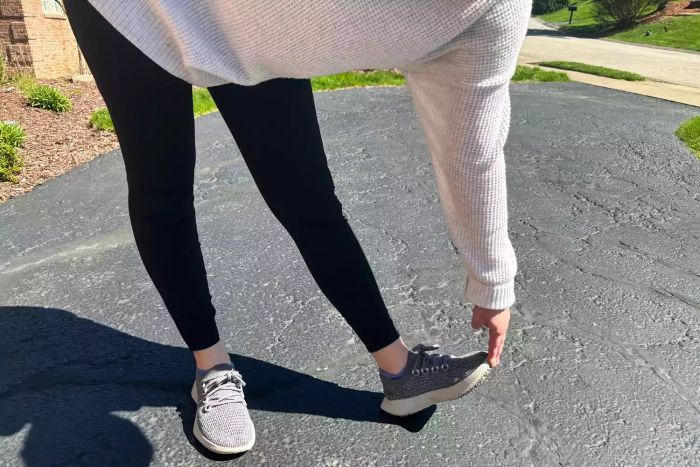 An individual stretches while wearing the Vuori Stride Legging