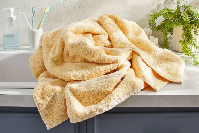 A Lands' End Premium Supima Cotton Bath Towel neatly balled up on a bathroom counter.