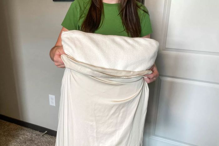 A person inserting a pillow into the Cozy Earth Bamboo Pillowcase