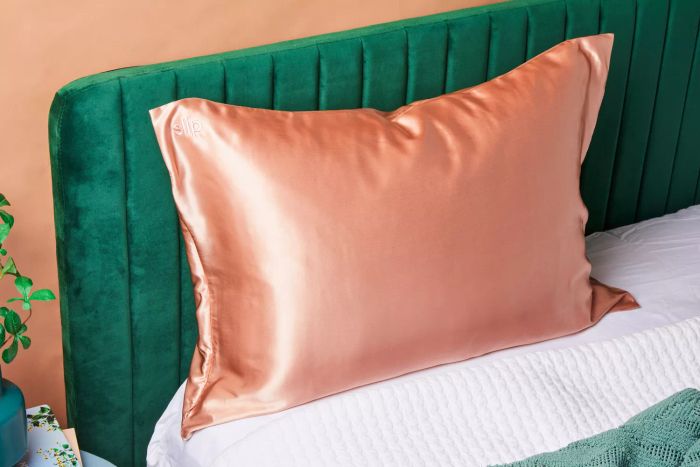 A pillow encased in a Slip Pure Silk Pillowcase, elegantly displayed on a bed