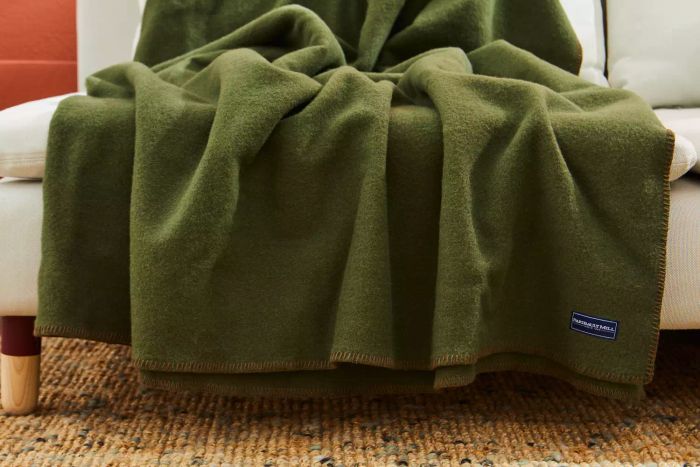 The Faribault Mill Pure & Simple Wool Blanket elegantly placed on a couch
